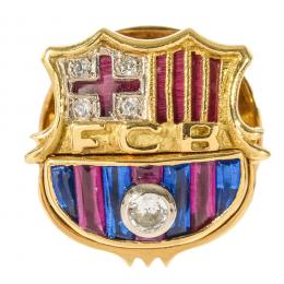 22   -  <p><span class="object_title">Insignia del Fútbol Club Barcelona en oro con diamantes talla brillante, 0,09 ct aprox., símiles de rubí y zafiros azules. 5,9 gr. </span></p>