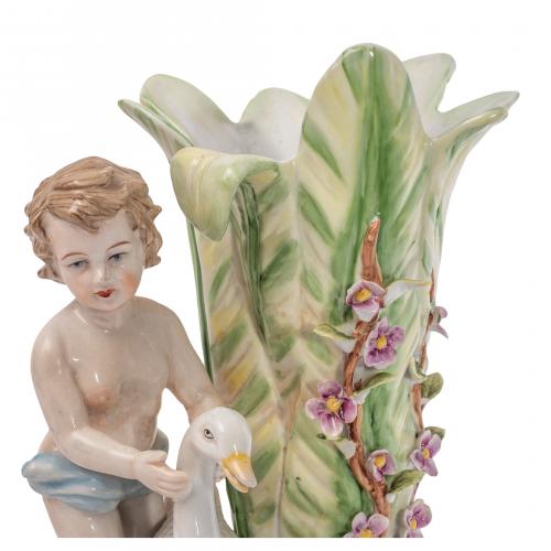 Centro flanqueado por amorcillo con oca en porcelana estilo